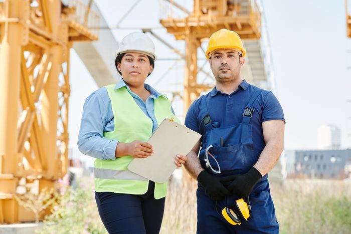 Site engineers in hard hats and safety vests