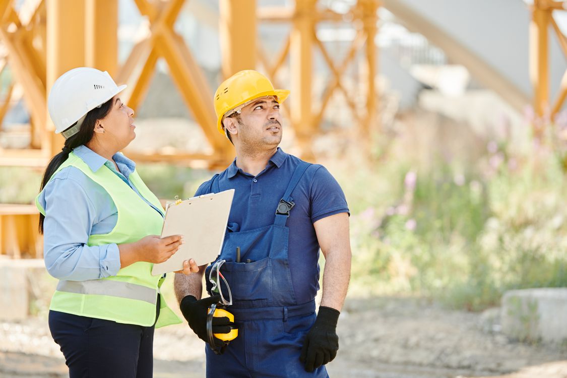 Workers in PPE at an active worksite where a real safety system is visible in field behaviour not just documentation