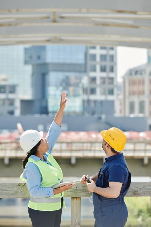 Free Two architects discussing plans at a city construction site with high-rise buildings. Stock Photo