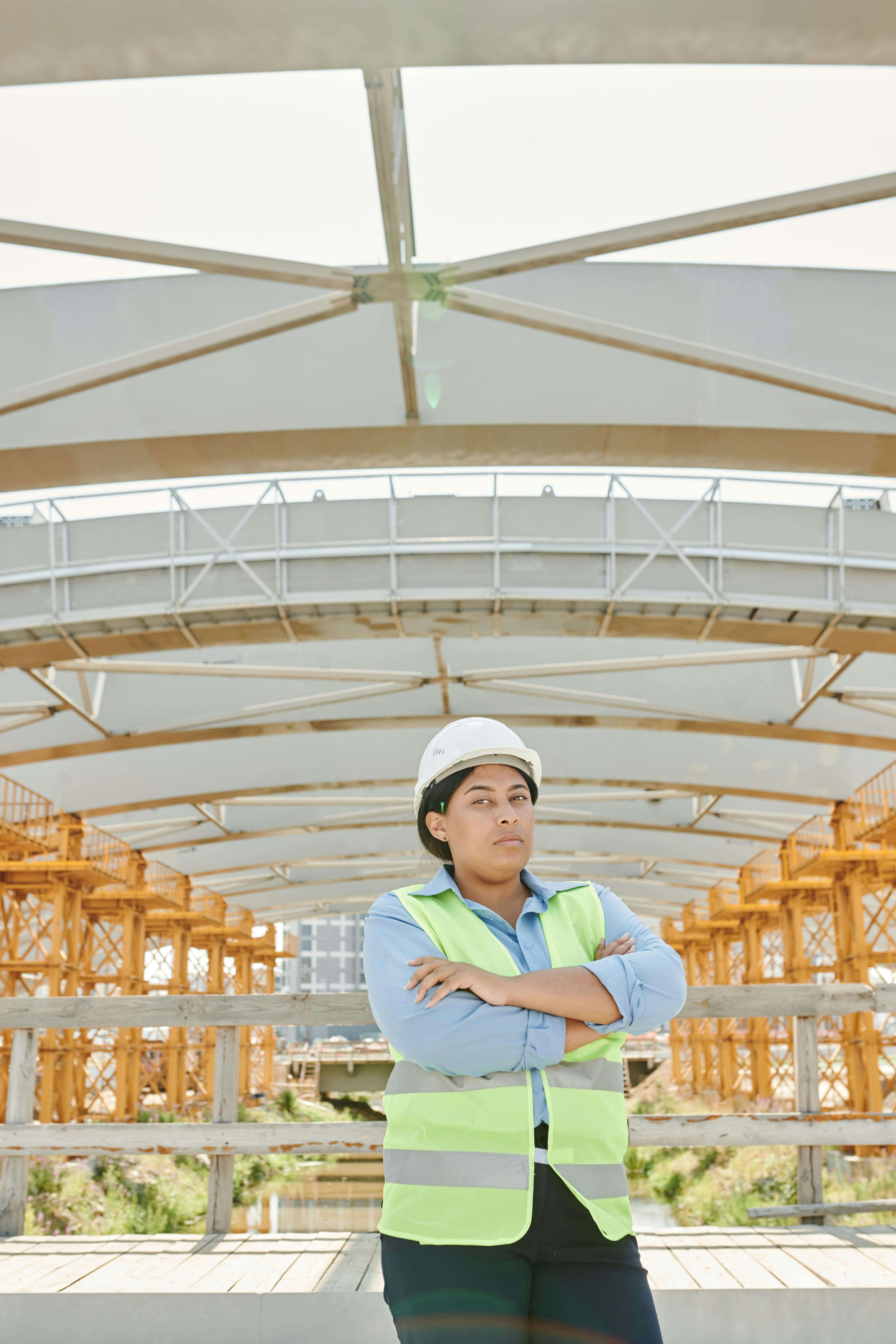 a woman wearing ppe standing under a truss