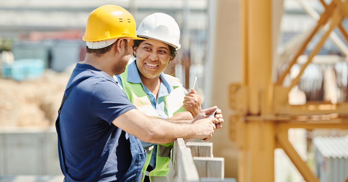 Two construction professionals reviewing plans at a building site