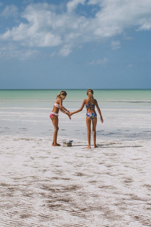 Free Two Girls in Bikini Standing on Beach Stock Photo