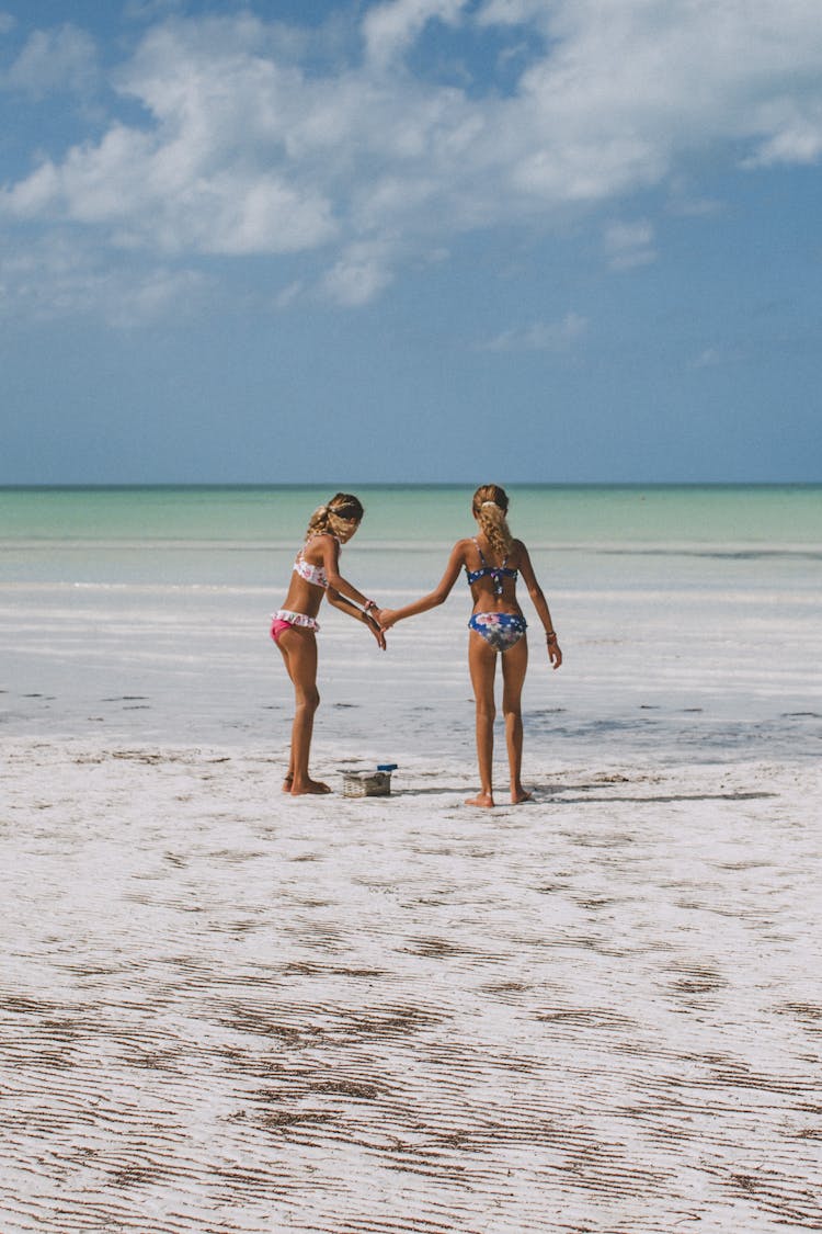 Two Girls In Bikini Standing On Beach