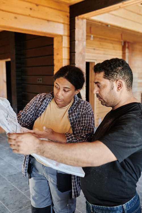 Free Man in Black Crew Neck T-shirt Looking On A Blueprint Beside a Woman Stock Photo