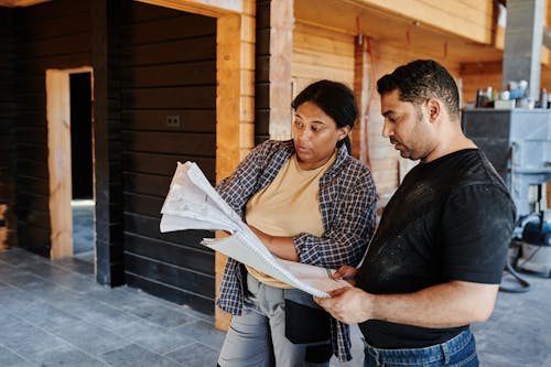 Man and Woman Looking at the Construction Plan