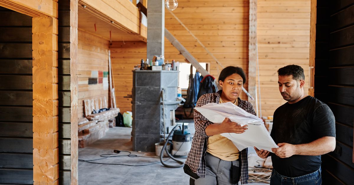 Construction worker carrying lumber on site, reflecting the skilled trades shortage in Canada
