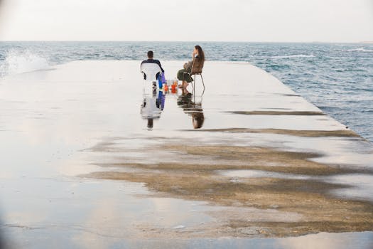 Couple on the Concrete Dock Near the Sea by dalia nava