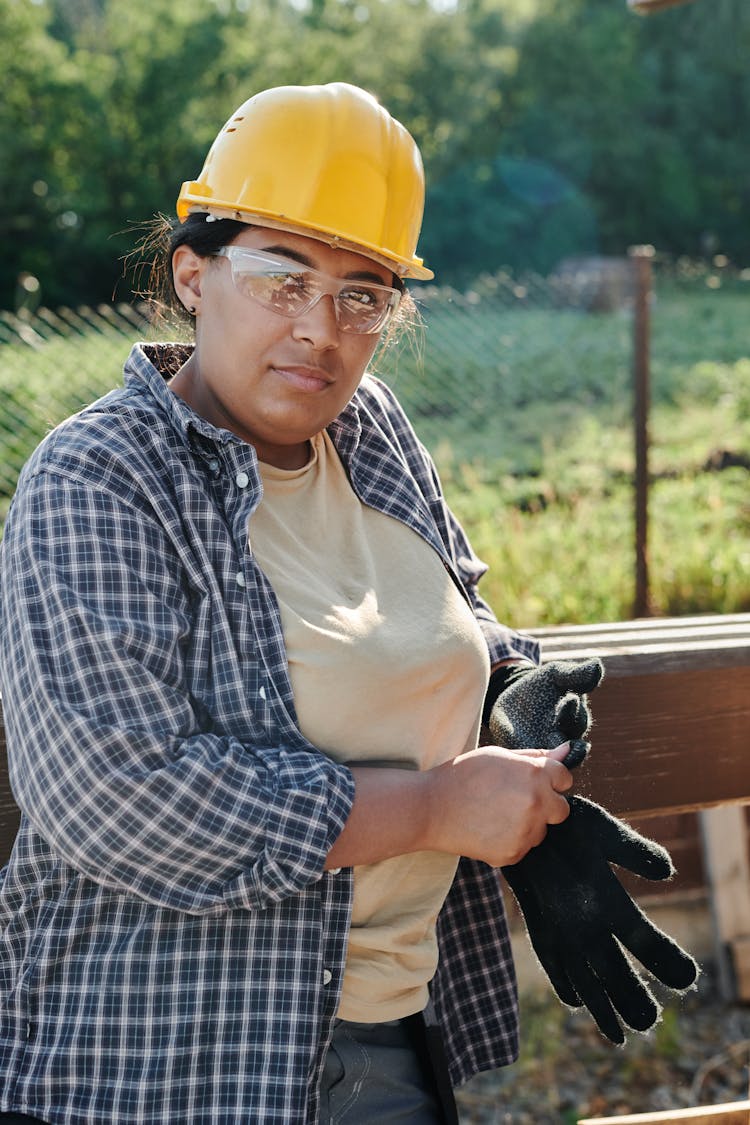 Woman In Work Clothes Wearing Hard Hat And Gloves