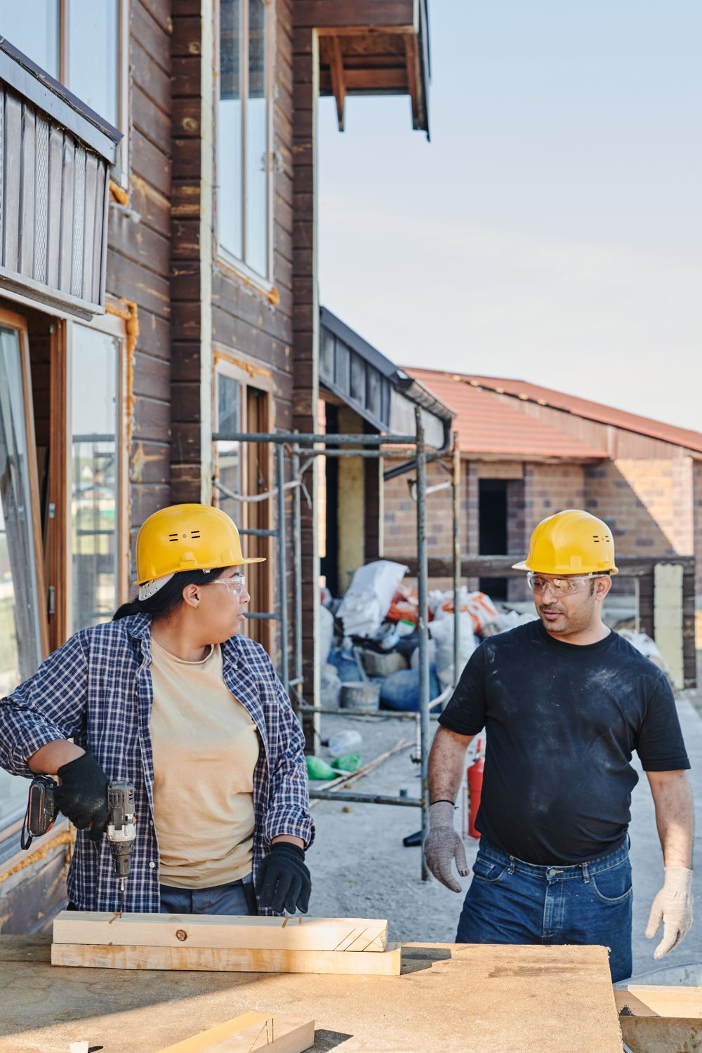 Two construction workers discussing building plans on site