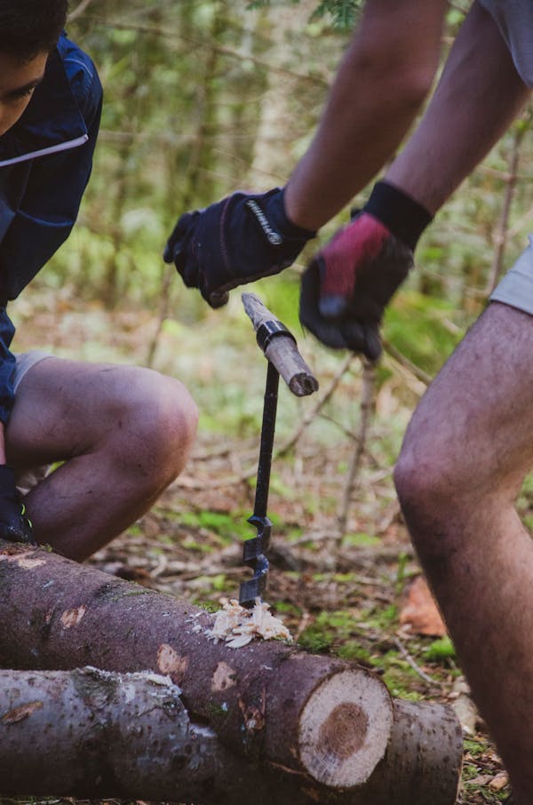 Painter applying paint to home exterior from ladder