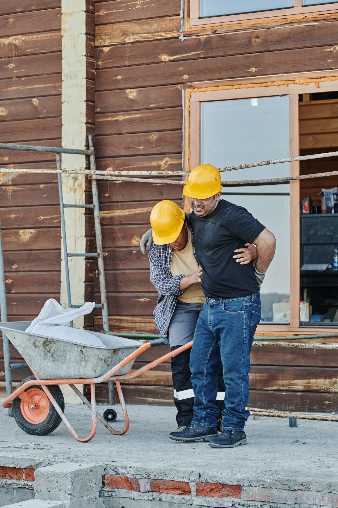 Construction workers assisting an injured colleague at a building site