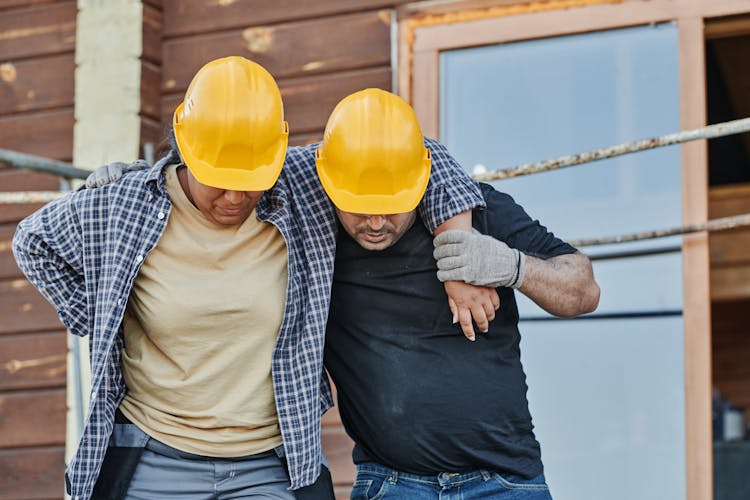 A Worker Supporting An Injured Co-Worker