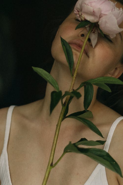 Close-Up Shot of a Woman Holding a Pink Rose