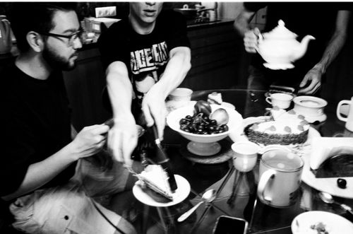 Free Artistic black and white photo of friends sharing dessert at a dining table Stock Photo