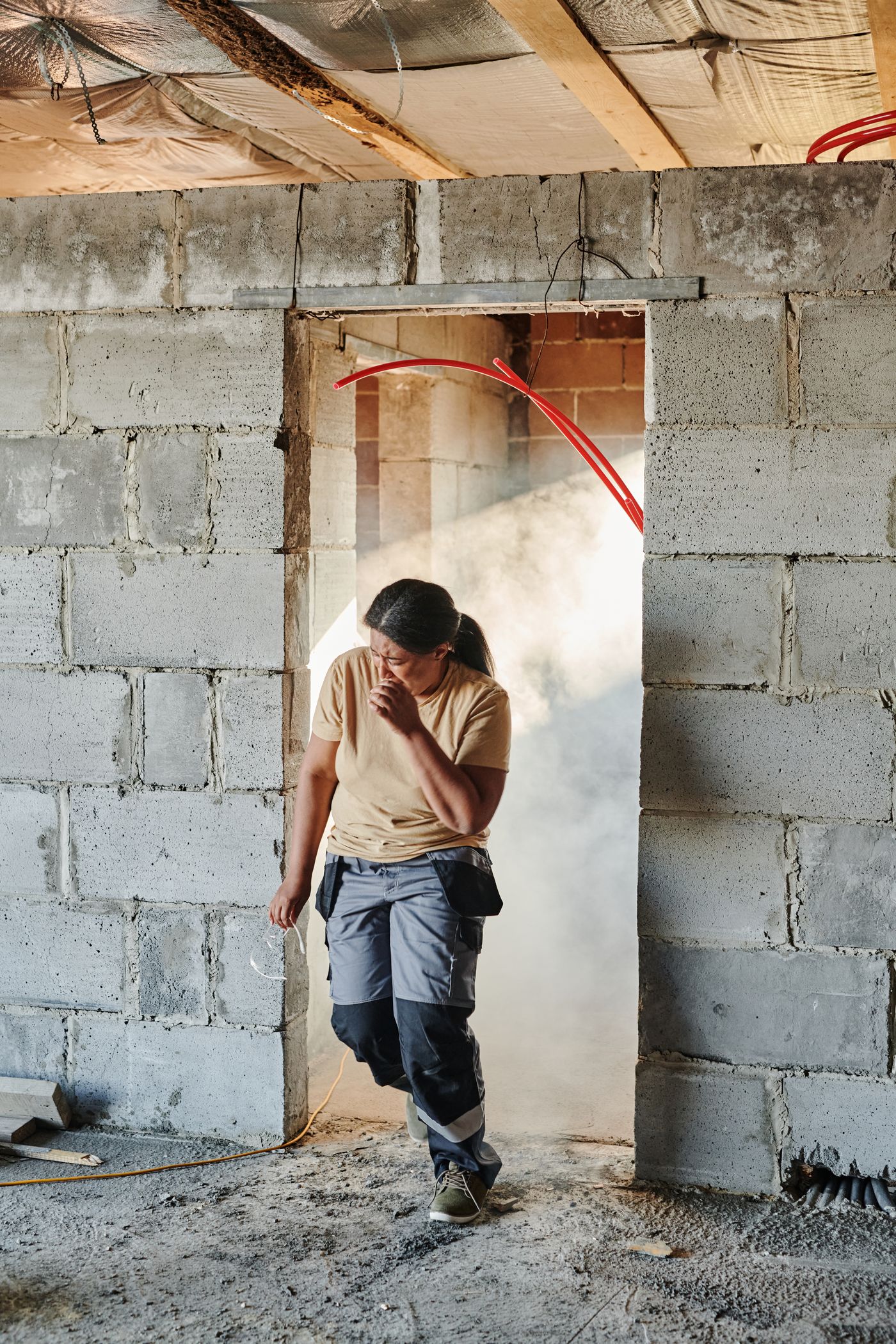 Construction worker standing in dust on a building site