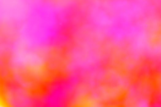 A vivid and abstract blurred background with a mix of pink, orange, and yellow hues.