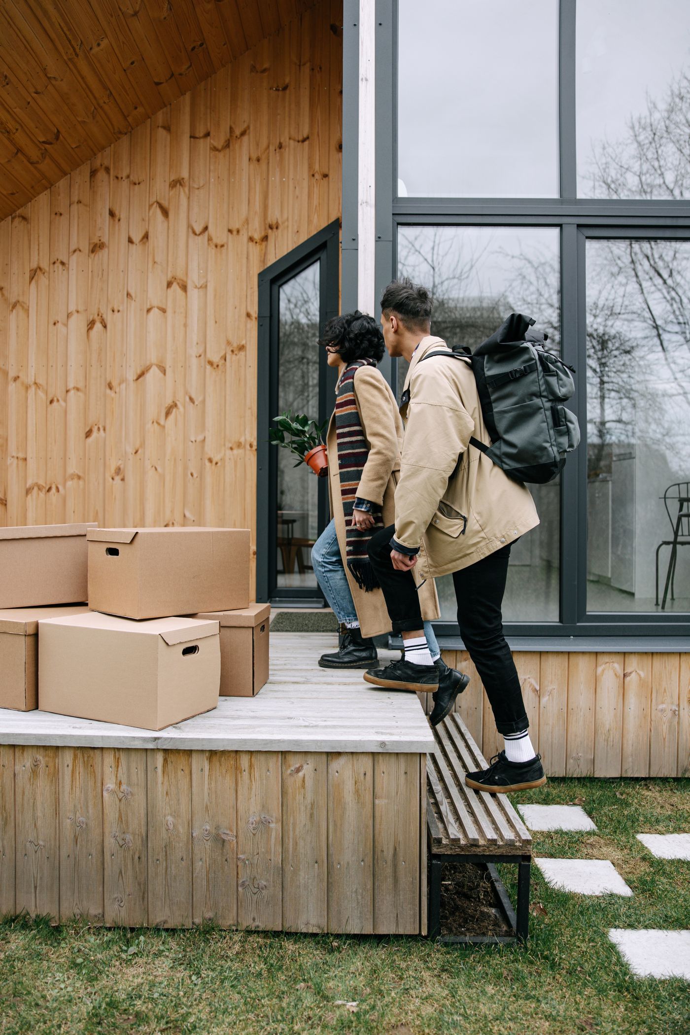 Couple carrying moving boxes into a new home