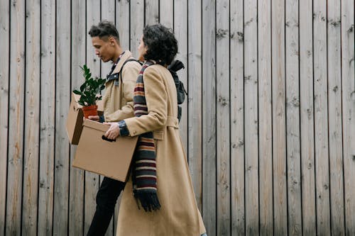 Free Couple Wearing Brown Coats Carrying Cardboard Boxes Stock Photo