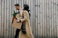 Man and Woman Kissing on Brown Cardboard Box