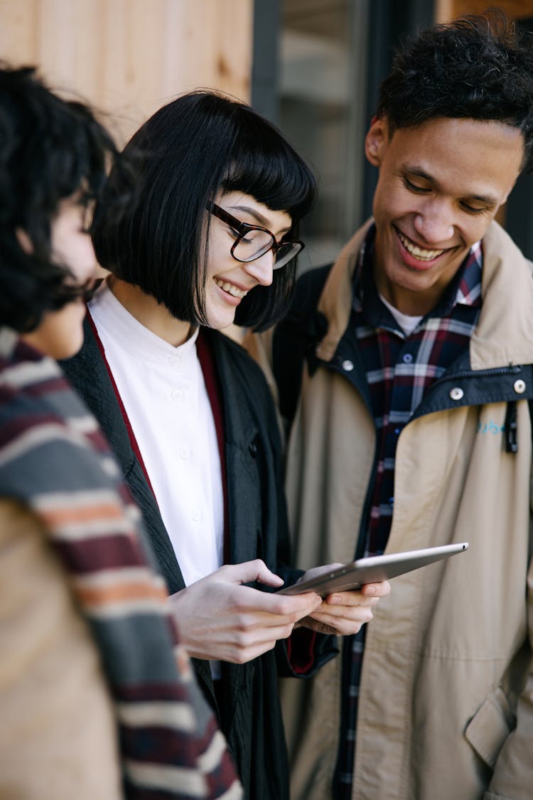 People Smiling While Looking At The Tablet Computer 