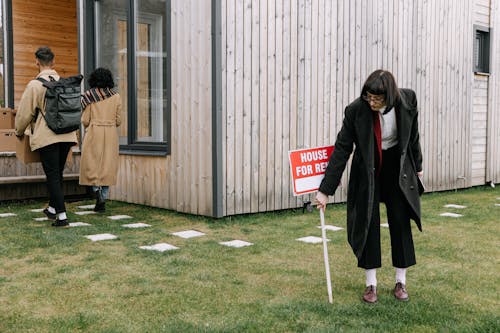 Free A Woman in Black Coat Holding a Placard on the Yard Stock Photo