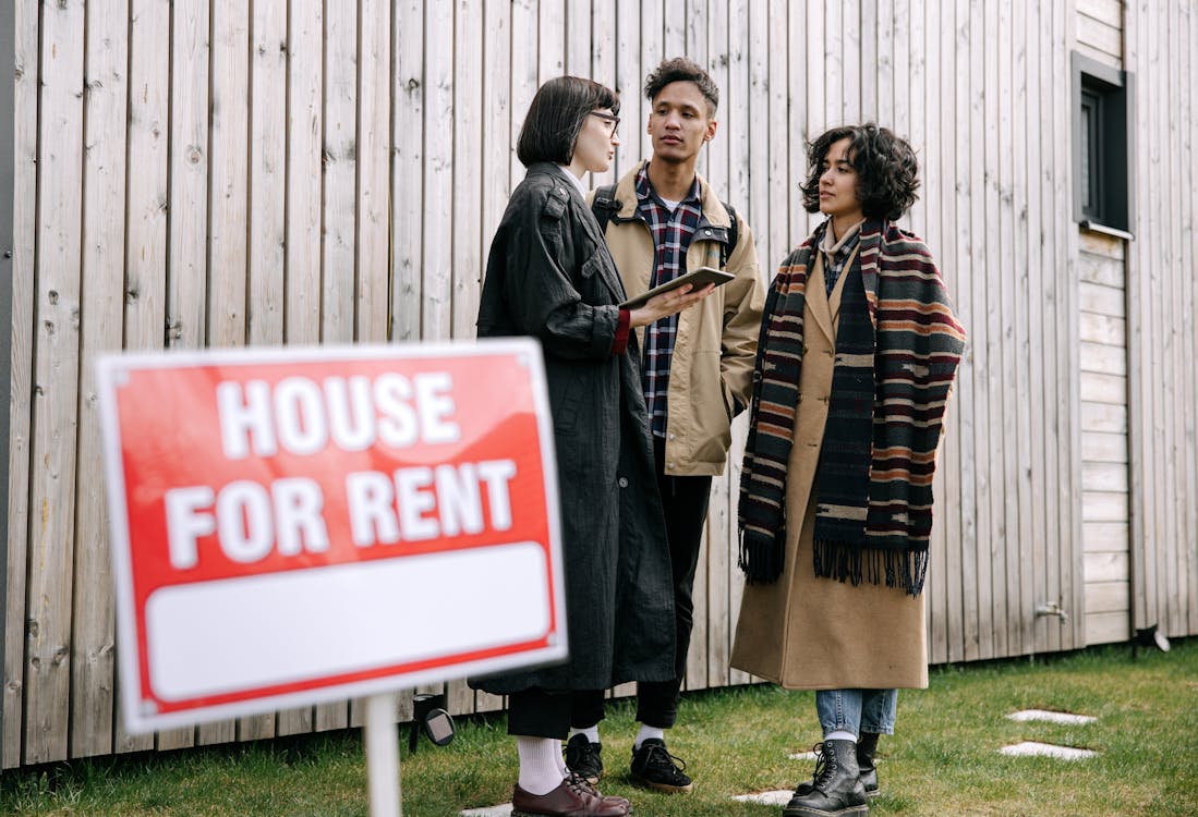 Free An interracial couple meets with a real estate agent to inquire about a house for rent. Stock Photo