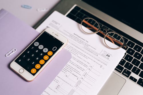 A Smartphone with a Calculator App over a Tax Document
