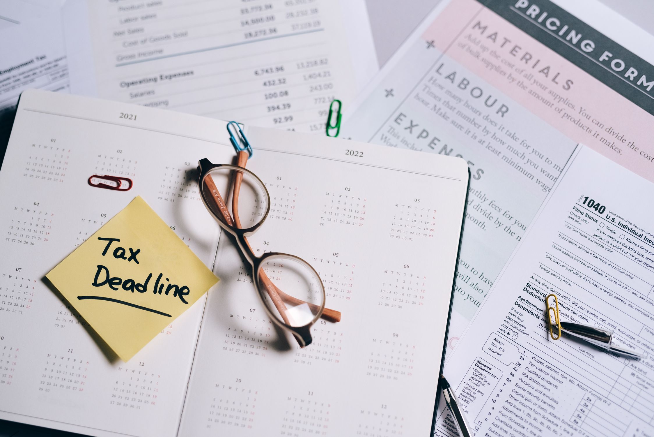 Open planner and accounting documents with financial deadline notes on a desk