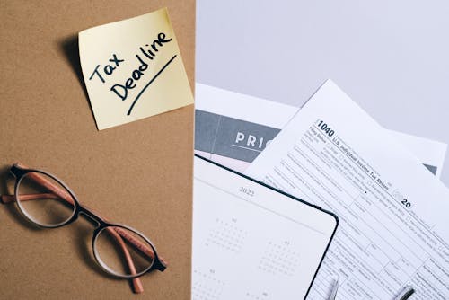 A Brown Envelope with a Sticky Note over a Planner and a Tax Document