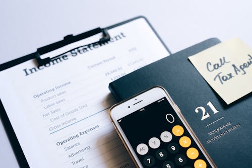Smartphone with Opened Calculator Lying on a Document with an Income Statement 