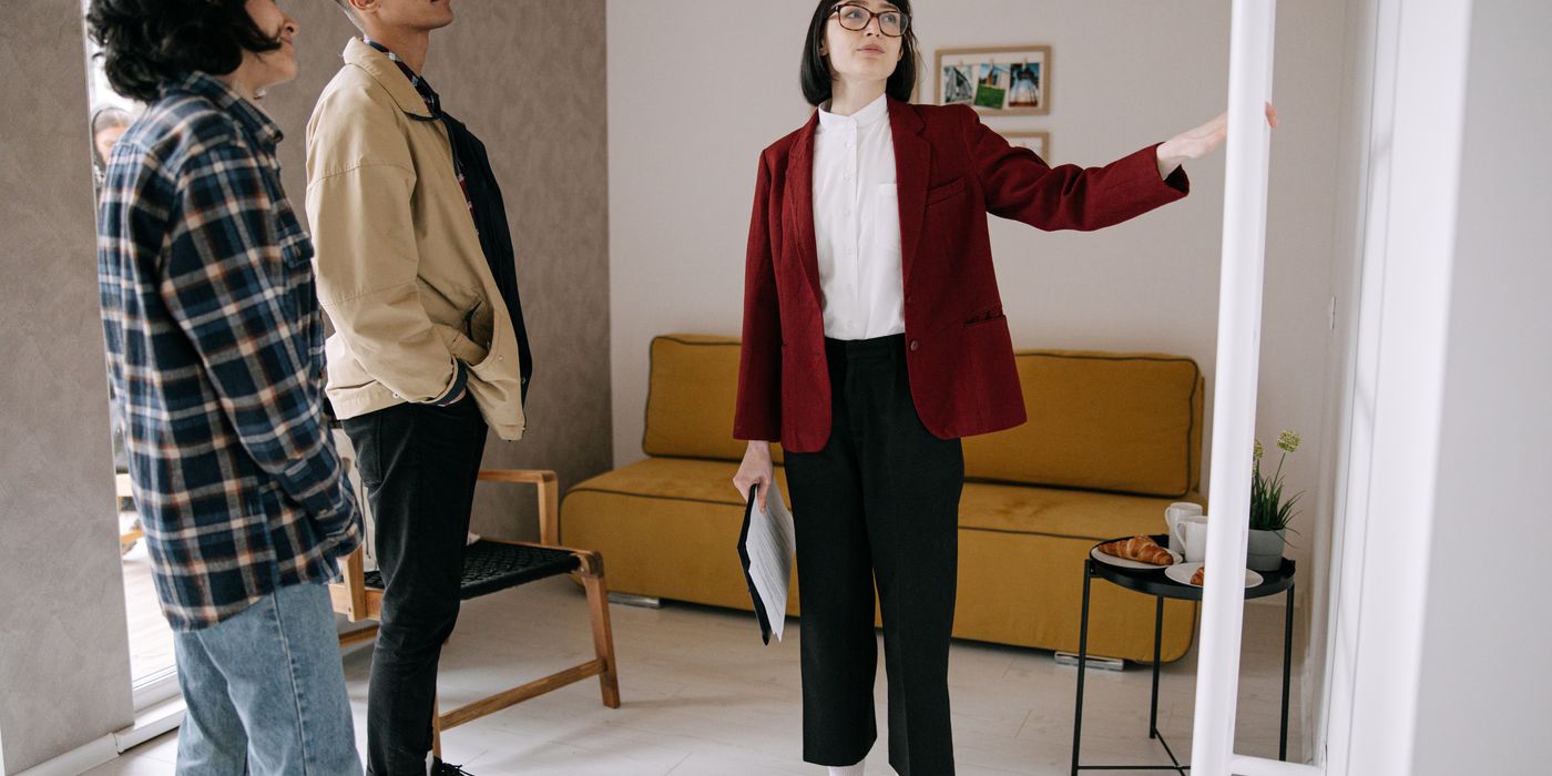 Realtor guiding potential buyers through a stylish apartment viewing.