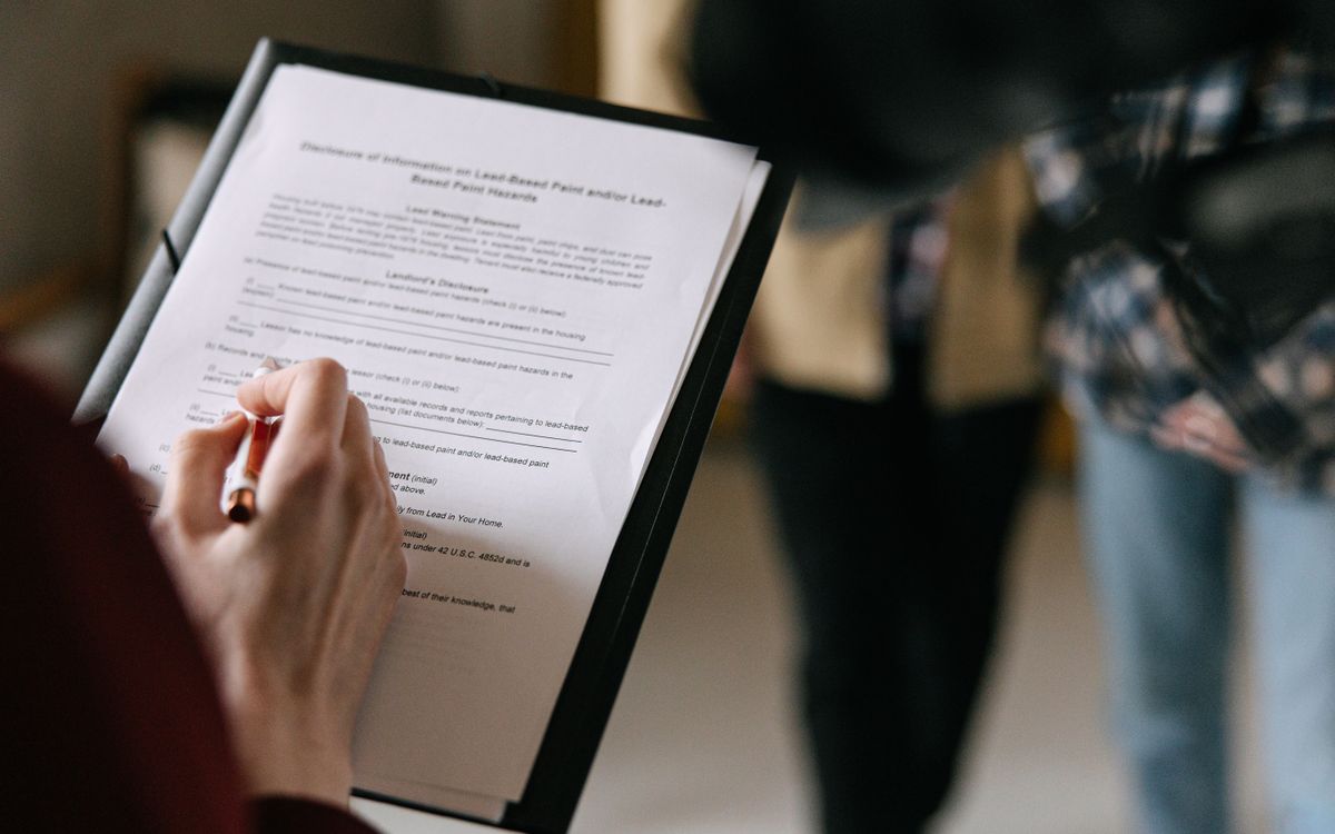 Couple reviewing documents with a property manager during a property consultation