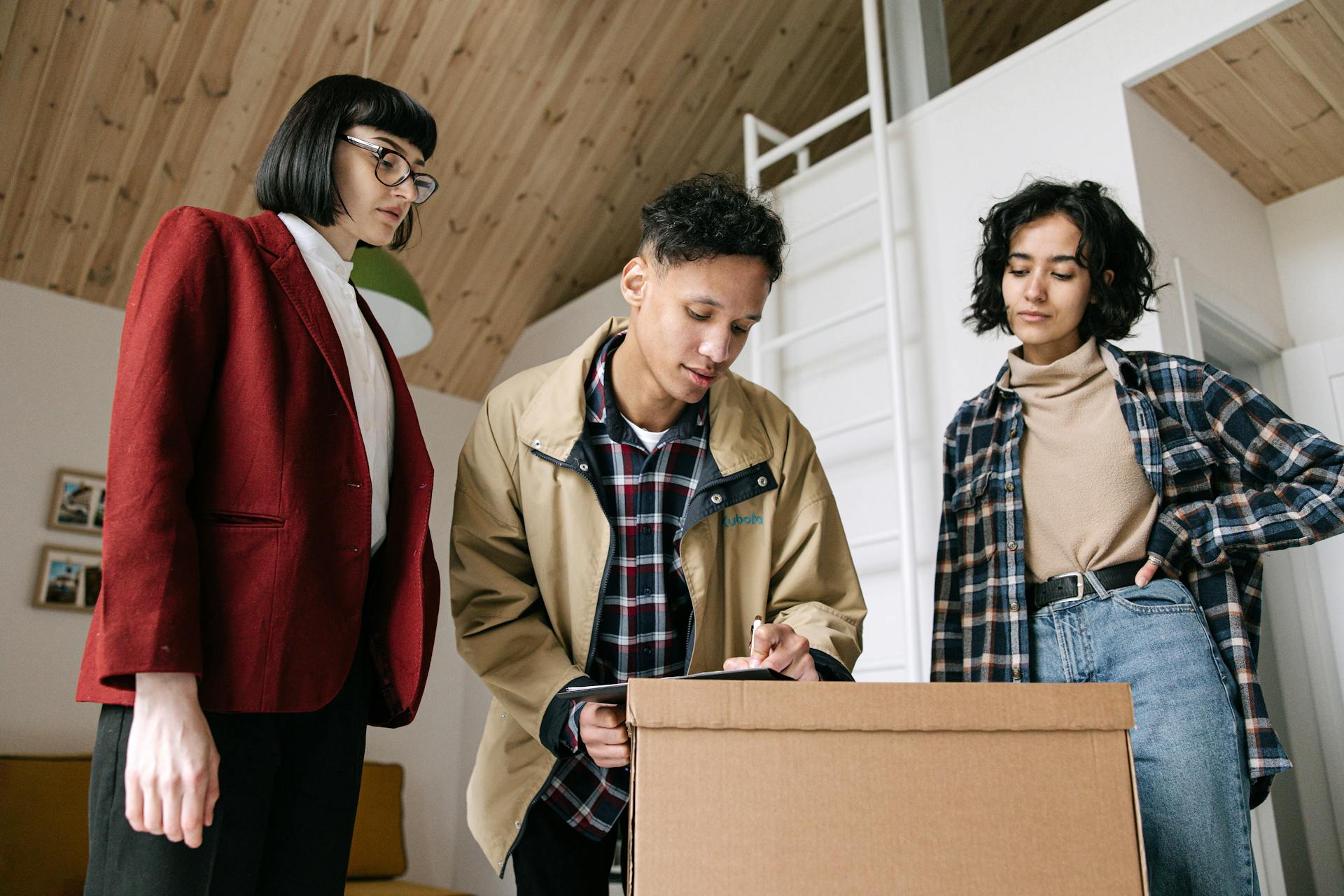 A couple signing documents with an agent, marking a new home purchase process.