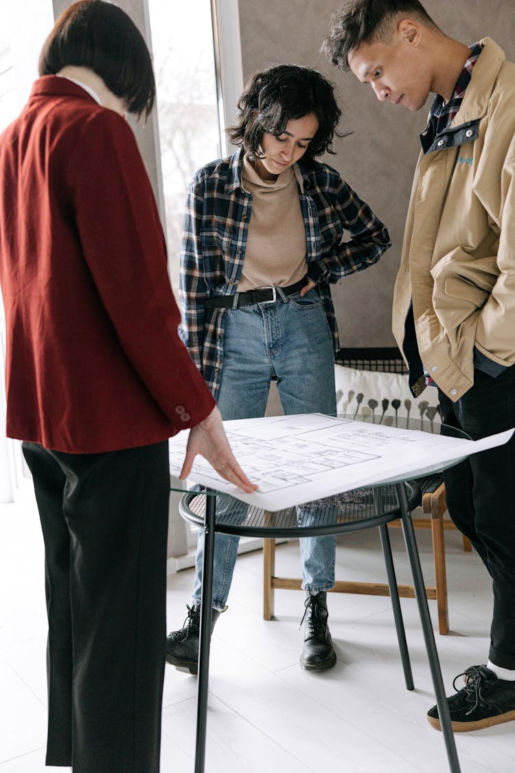 A Couple And An Architect Looking At A House Plan 