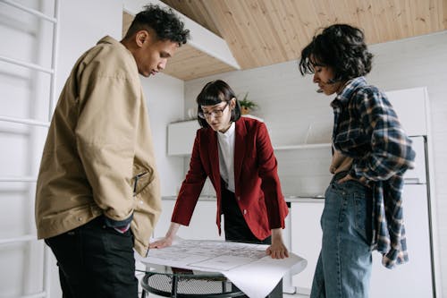 Woman Showing Blueprint to a Couple