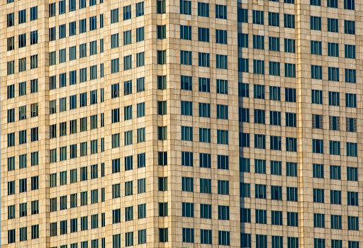 Close-up view of modern skyscraper facade highlighting glass windows and concrete structure.