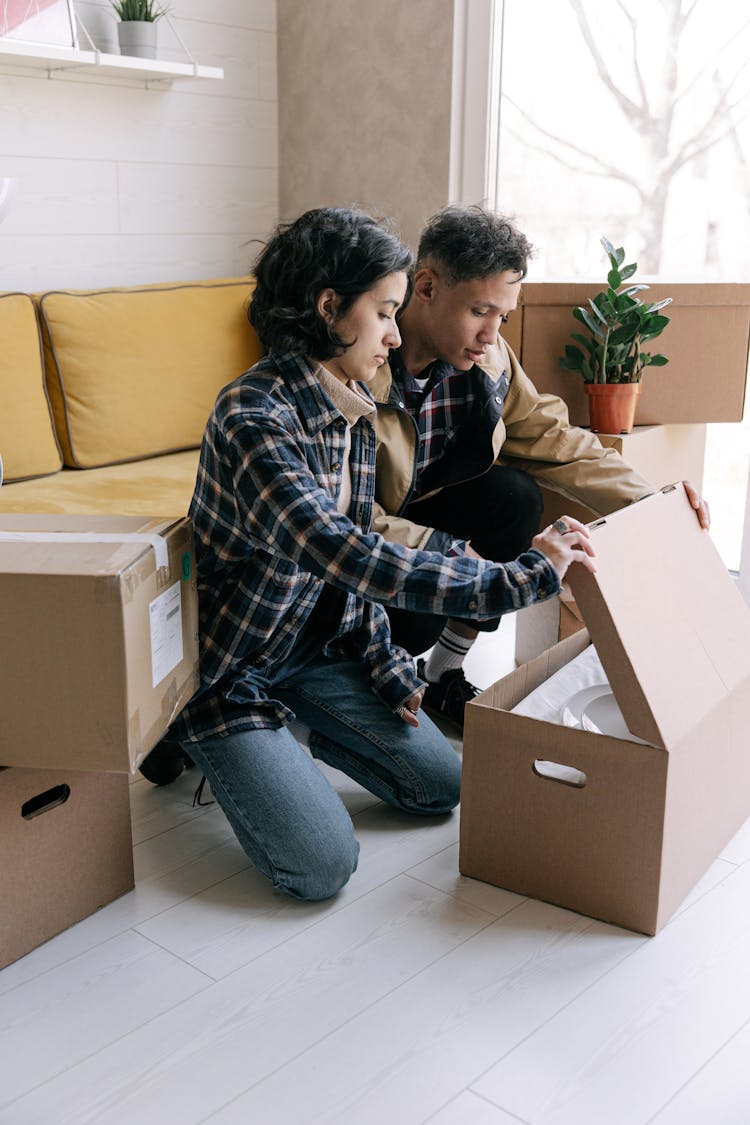 A Couple Holding A Carton Box