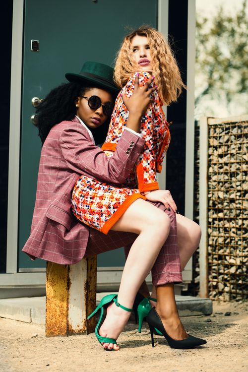 Free Chic fashion duo posing outdoors in vibrant outfits and stylish accessories. Stock Photo