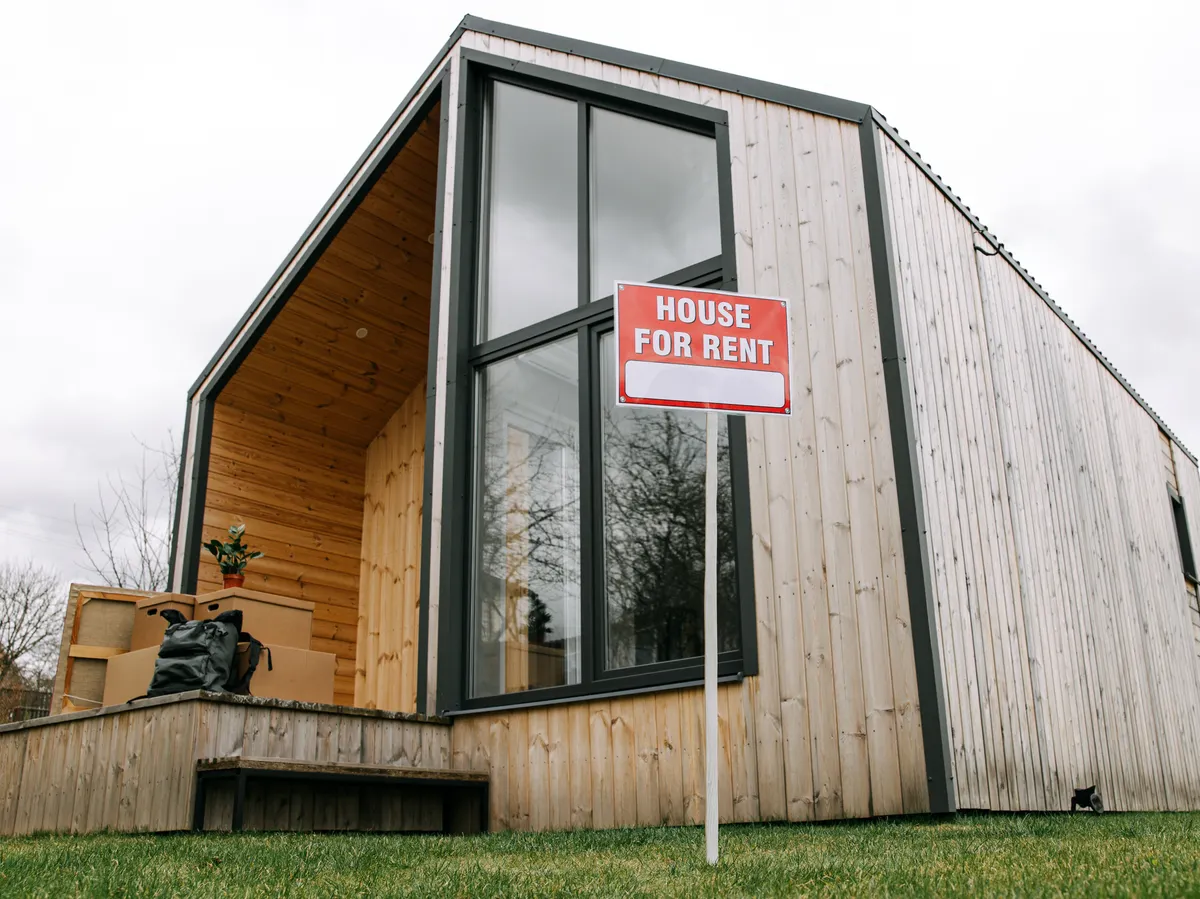 Home with a sign out front, representing the sell-or-rent decision