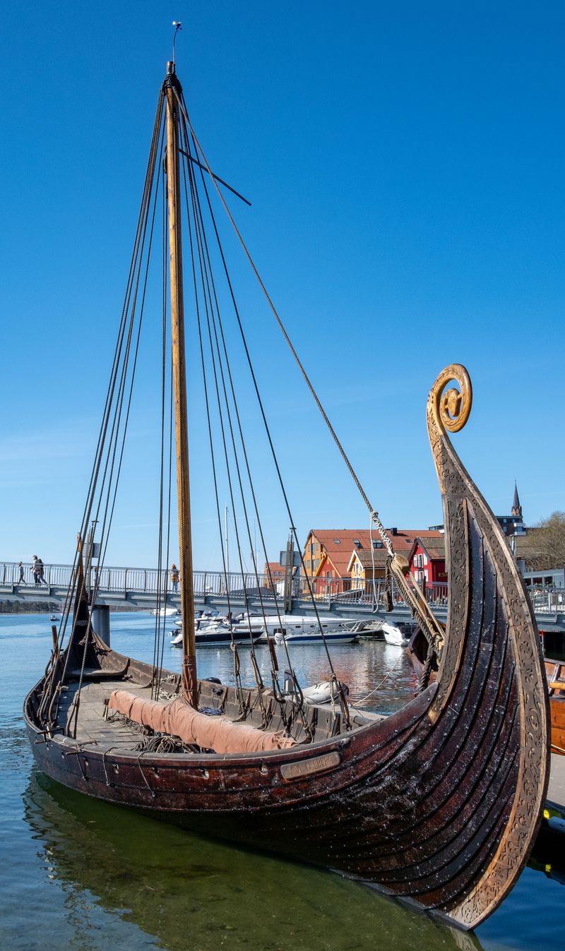Wooden Viking ship docked in Tønsberg harbour Norway with mast and carved details visible