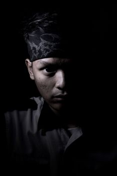 一幅光影对比强烈的男子肖像，显得喜怒无常