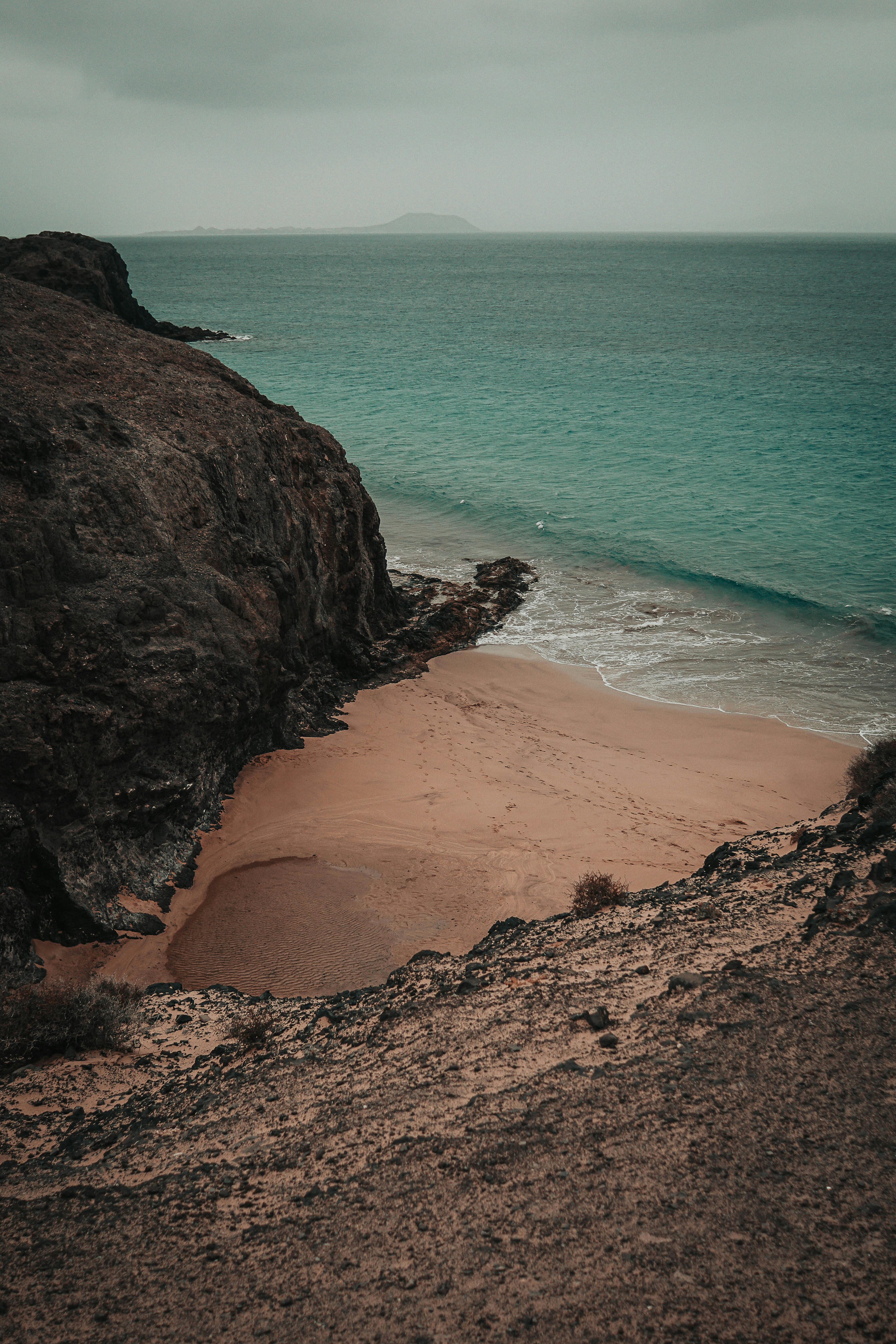 Explore the rugged beauty of Lanzarote's coastline with stunning cliffs and serene sandy beaches.
