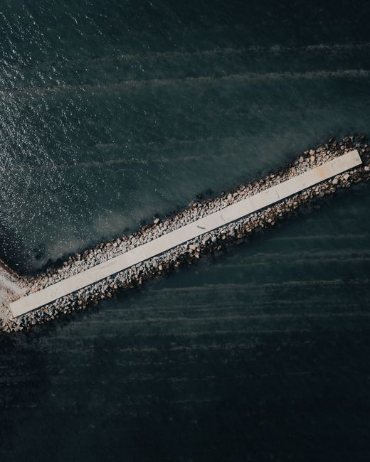 Drone shot of a long pier in Anapa, Russia extending into the sea.