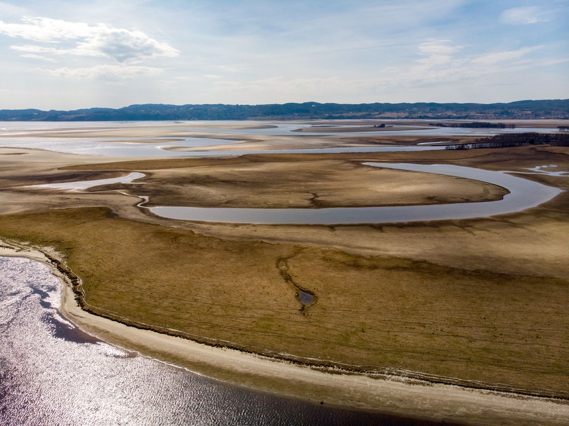 A breathtaking aerial shot capturing the graceful curves of a river delta blending into the vast landscape.