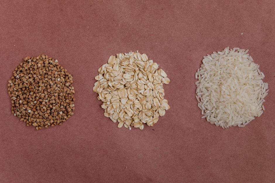 Varieties of whole grains like quinoa, brown rice, and oats in wooden bowls - diet food breakfast lunch and dinner Varieties of whole grains like quinoa, brown rice, and oats in wooden bowls - diet food breakfast lunch and dinner