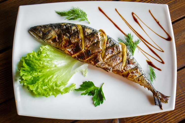 A Cooked Fish On A Ceramic Plate