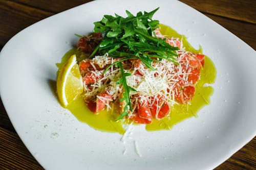 A Plate of Carpaccio Topped with Arugula