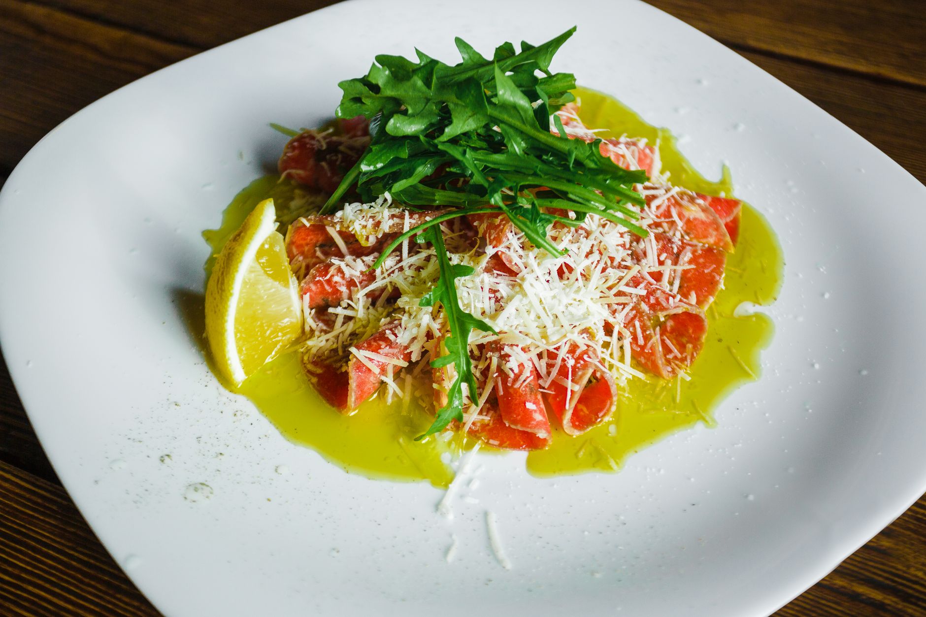 地中海飲食與長壽村的真實關聯:吃出健康長壽的科學秘密 Salmon carpaccio garnished with arugula, cheese, lemon, and olive oil.