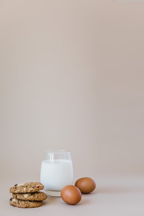 Glass of Milk Beside Two Brown Eggs and Cookies