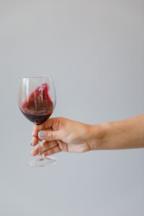 Free Close-Up Shot of a Person Holding a Glass of Red Wine Stock Photo